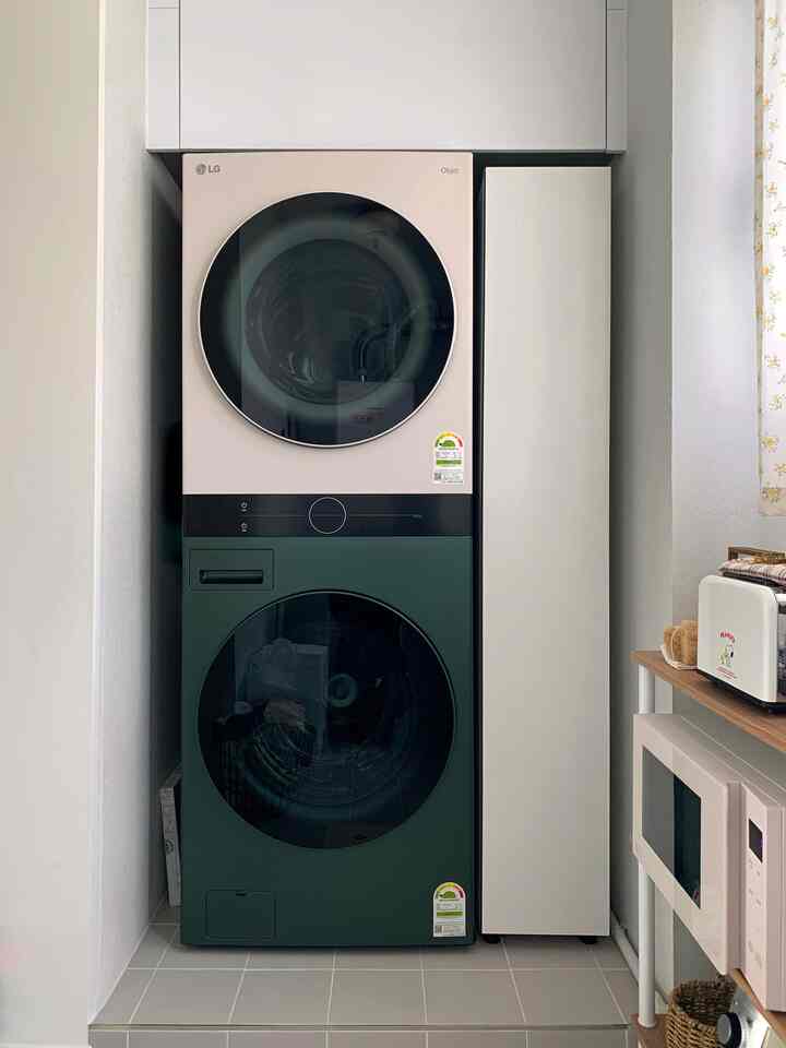 White background laundry space featuring beige washing machines and narrow gap storage cabinet with clean, efficient design