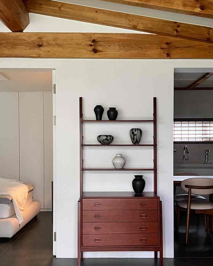 ブラウンウッドトーンと白い壁が調和したミッドセンチュリーモダンスタイルの寝室と隣接するダイニングルーム