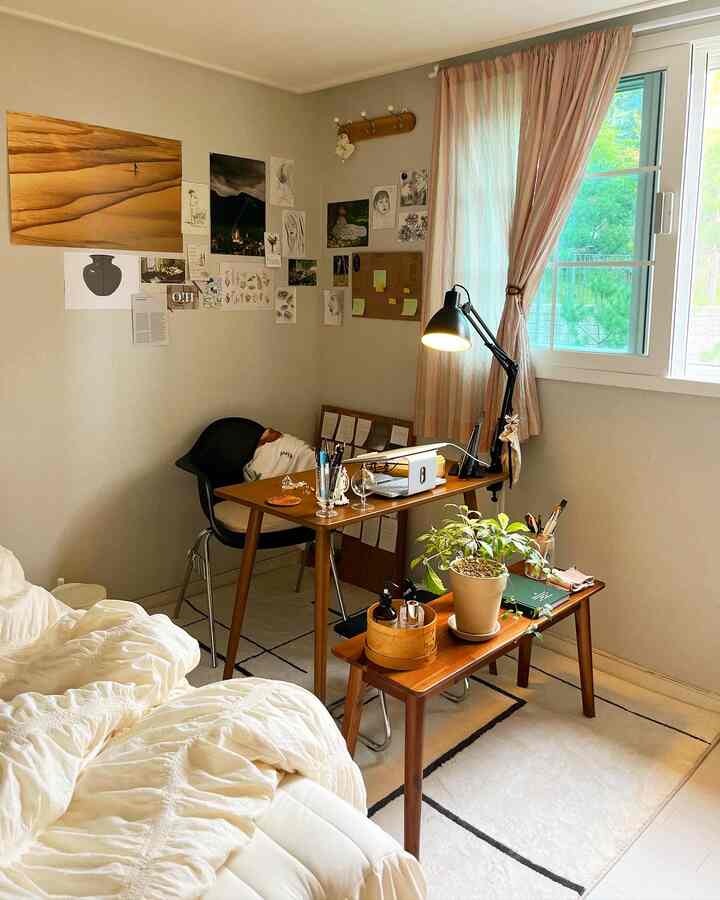 Natural-tone compact bedroom and home office space for a single household featuring wood furniture and soft lighting
