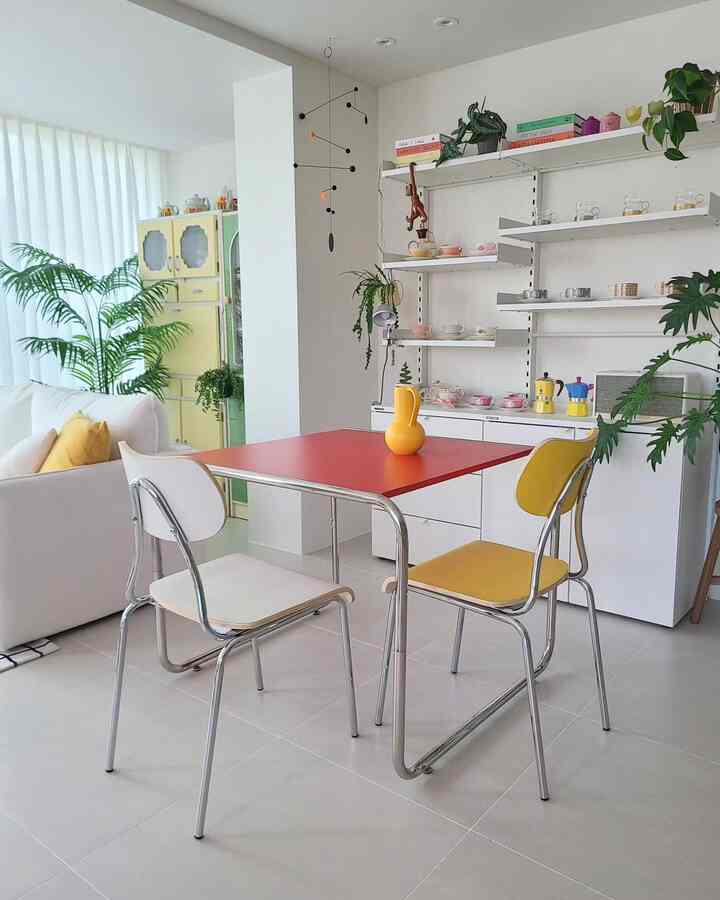 赤と黄色のアクセントが映える明るいリビング兼おうちカフェ、ミッドセンチュリーモダン家具と植物が配置された雰囲気のあるインテリア