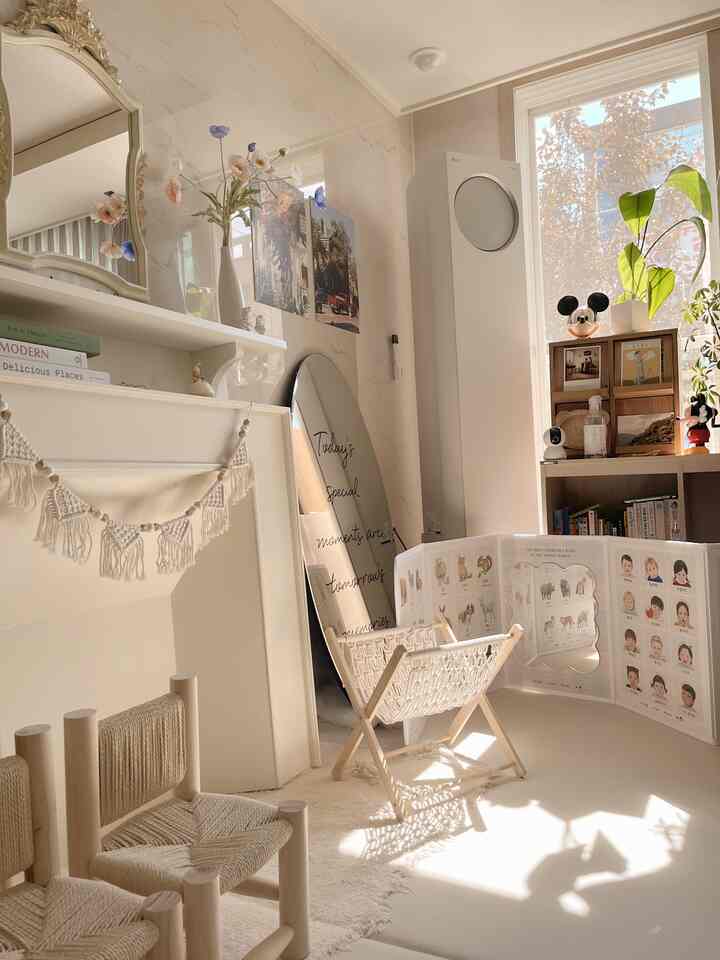 ナチュラルなベージュ色調のリビング、赤ちゃんの遊びスペースと自然素材の家具が配置された温かみのあるインテリア