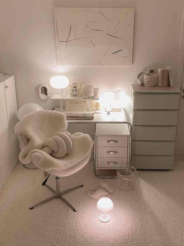 柔らかな白を基調としたコンパクトなホームオフィス、シンプルな家具と照明が配置された落ち着いた作業空間