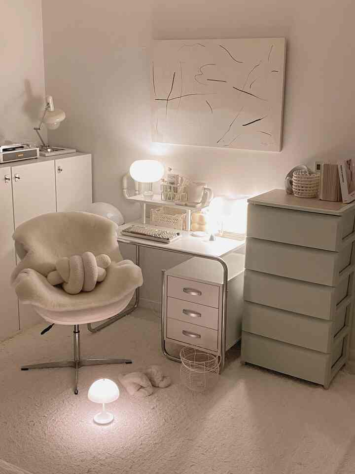 Warm white-toned study featuring a cozy swivel armchair, practical desk with drawers, and soft ambient lighting creating a welcoming atmosphere