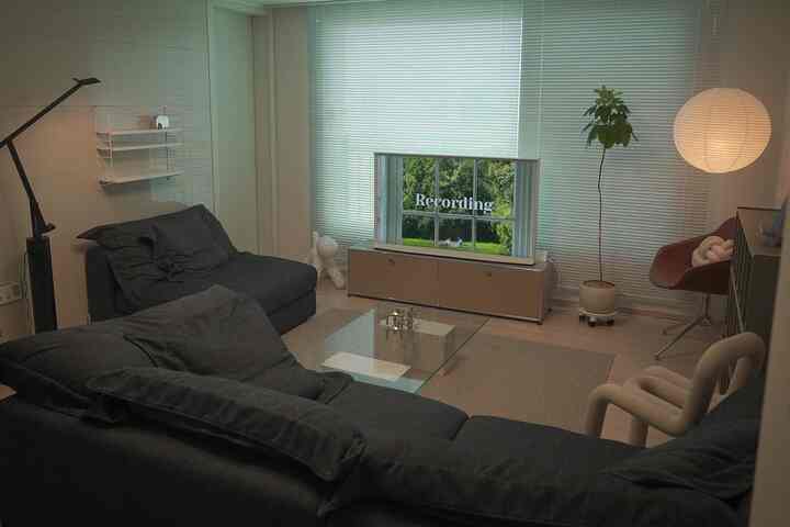 Modern living room in black and white tones, featuring large sofas and a TV stand with a clean aesthetic