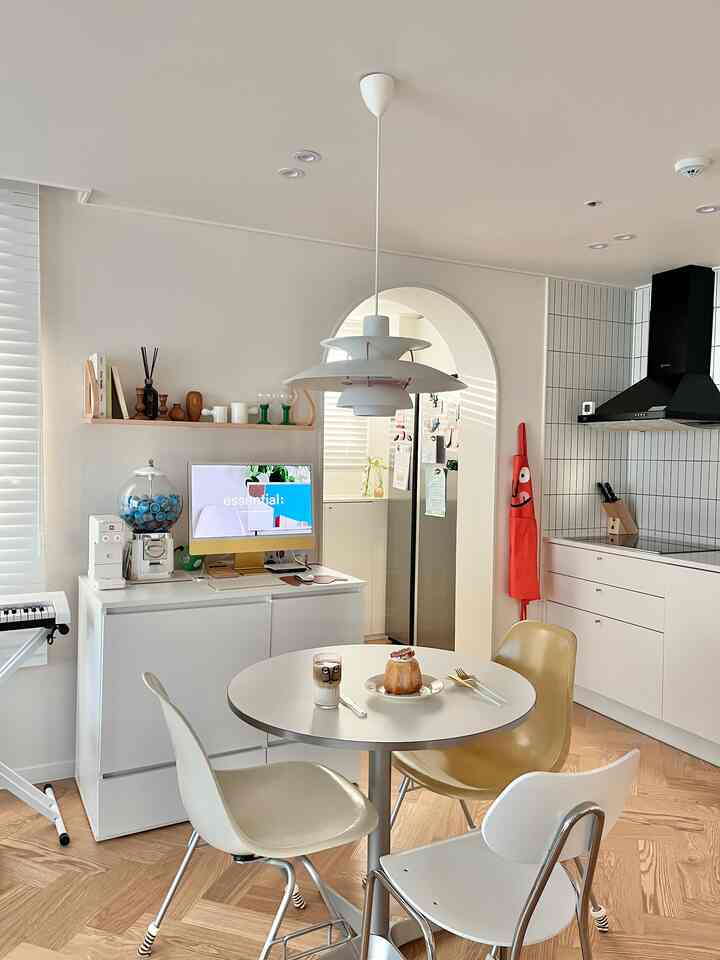 White and wood tone kitchen and dining room featuring a round table with chairs in a modern, open atmosphere