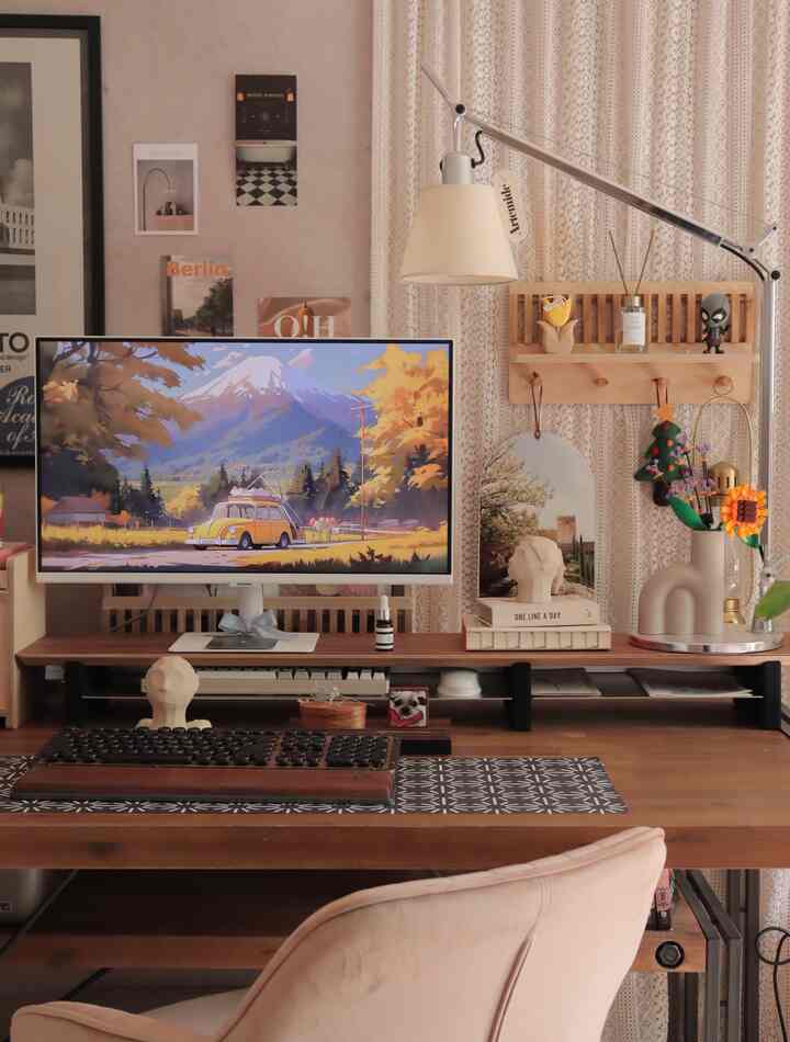 Warm ivory and wood tone home office space featuring a table lamp and monitor on a cozy desk setup