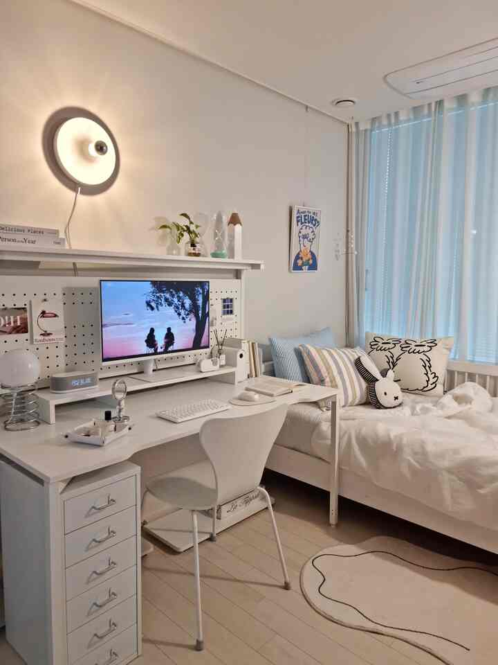 白を基調とした子供部屋、広いデスクとベッド、壁付けライトが配置されたシンプルな空間