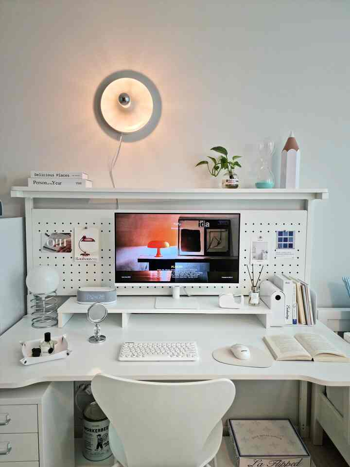 ホワイトトーンのホームオフィス子供部屋、ホワイトデスクとモニター、壁ブラケットライトとペグボードが整然と配置された印象的な空間