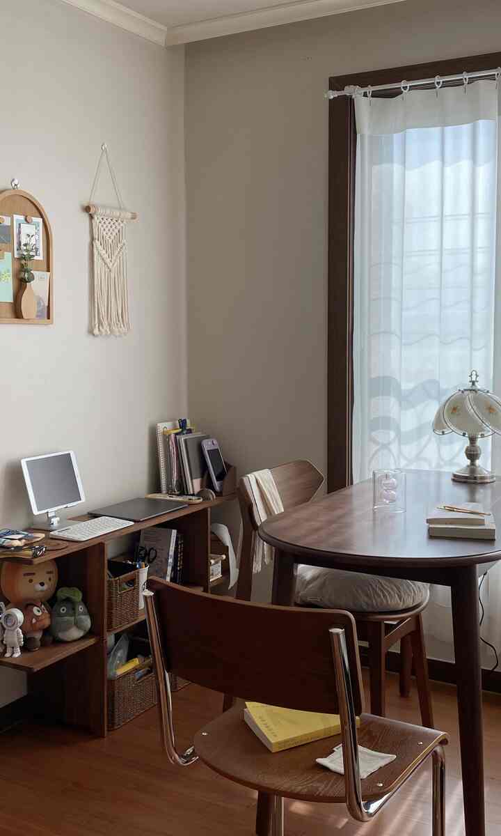 ナチュラルな木目調が特徴のホームオフィス兼ダイニングルーム、ダイニングテーブルと椅子、本棚が配置された落ち着いた空間