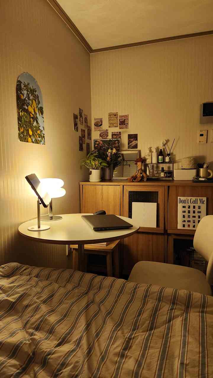 Light brown and beige toned bedroom featuring a round table and storage cabinet creating a cozy, functional atmosphere