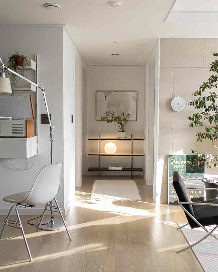 Natural color and white-toned Nordic living and hallway space featuring simple furniture, lighting, and plants in a bright and clean interior