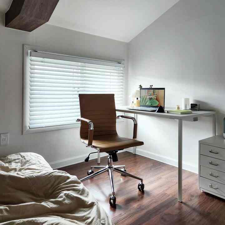 Natural modern home office with harmonious white and wood tones, featuring an office chair and desk in a cozy workspace