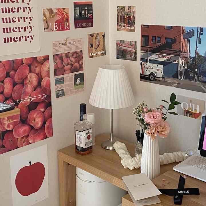 Warm natural-toned home office featuring a wooden desk with a white vase and table lamp creating a cozy workspace