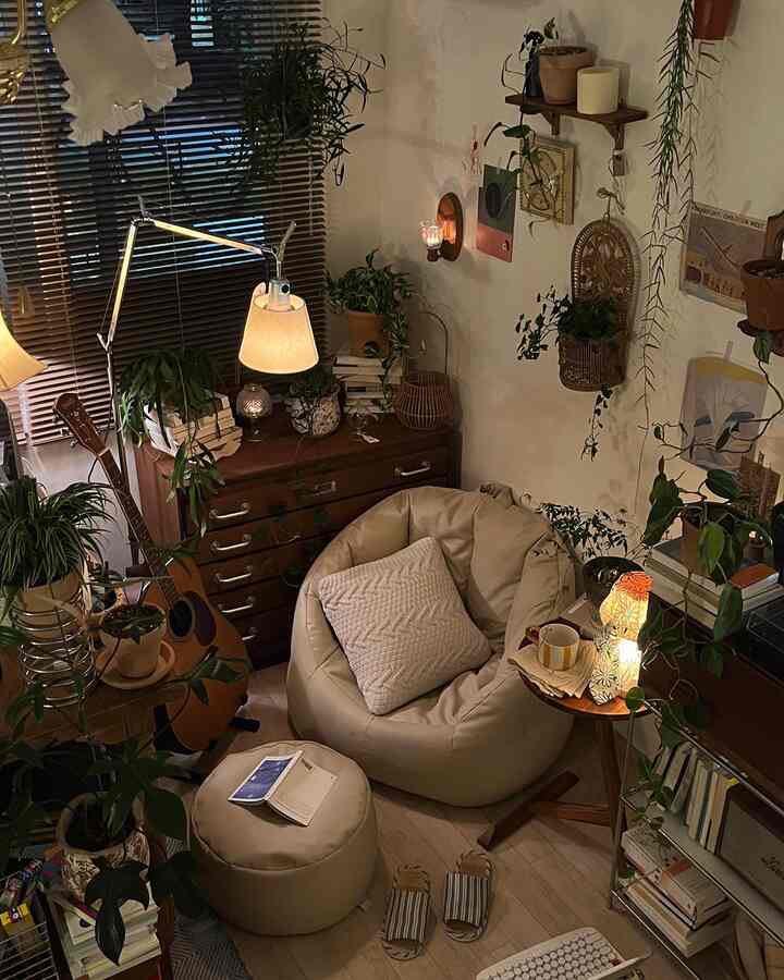 ベージュとブラウンの色調の小さな部屋、ビーズクッションと多様な植物が配置された雰囲気のあるインテリア