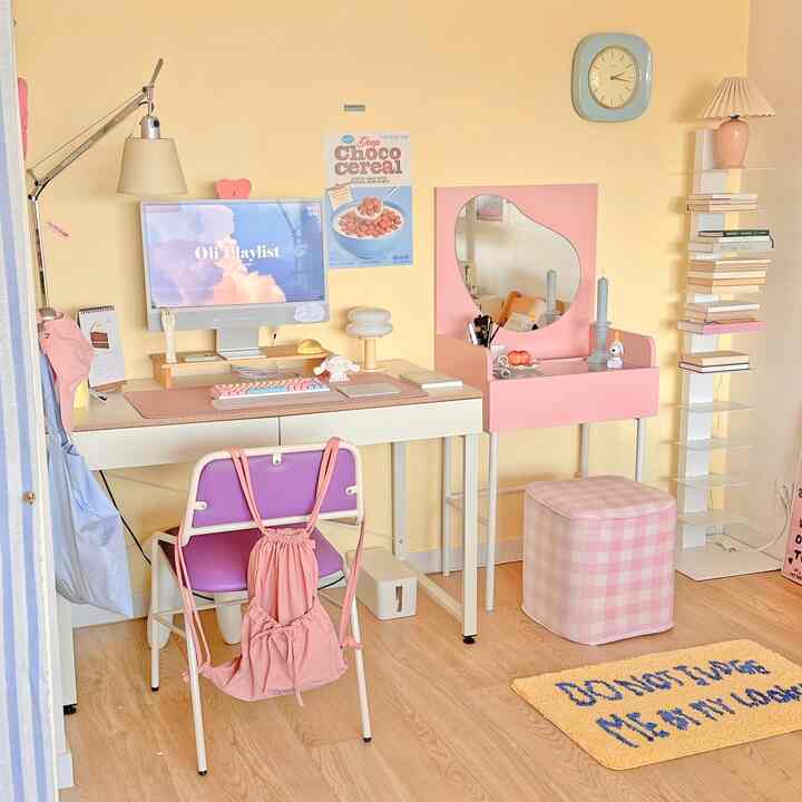 パステル調の寝室、ホワイトデスクとピンクのハート形の鏡付き化粧台、チェック柄のスツールが配置された雰囲気のあるインテリア