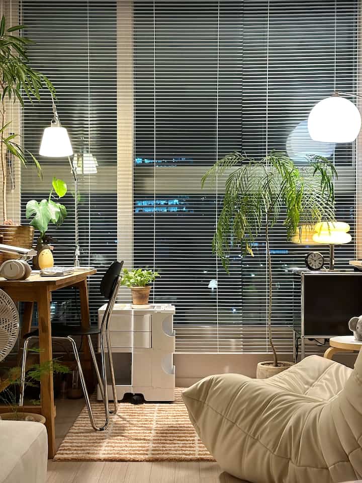 White and wood tone home office space featuring various plants and lighting creating a cozy atmosphere