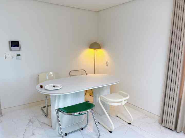 Bright white-toned mid-century modern dining room featuring diverse dining chairs neatly arranged around table