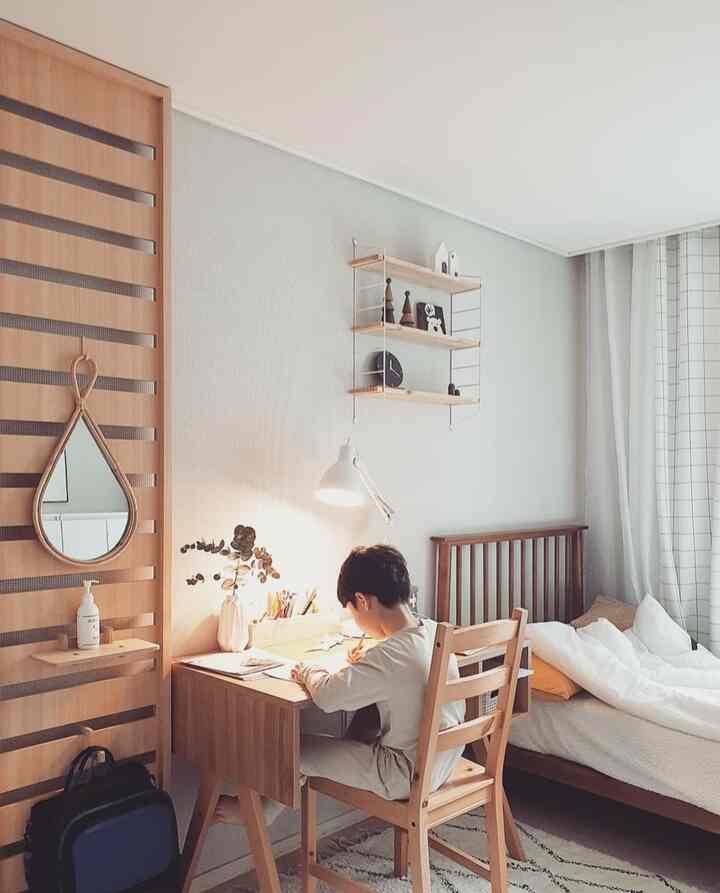Natural wood tones and white hues blend in a kids' room featuring a desk, bed, and shelf arranged neatly for a cozy atmosphere