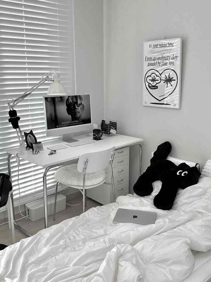 白と黒のモノトーン調2.5坪ワンルーム、机とベッドが配置されたミッドセンチュリーモダン風のインテリア