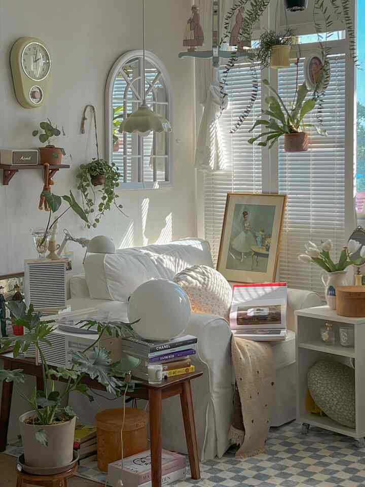 白とブラウンのウッドトーンが調和した、植物とソファが配置された明るくナチュラルなリビングルーム