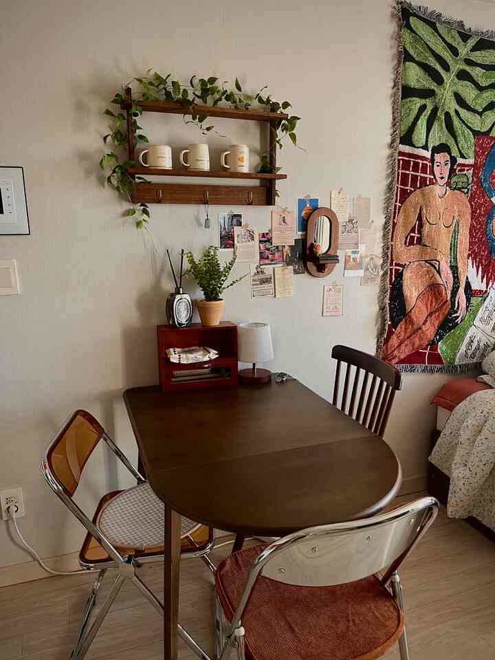 木目調とベージュ壁のワンルームダイニングスペース、ビンテージのインテリアと壁飾りが温かみのある雰囲気を作り出す