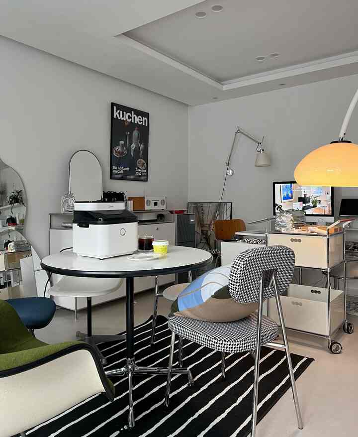 白と黒を基調としたモダンなダイニングルーム、ミッドセンチュリーモダンのダイニングテーブルとチェアが配置された印象的な空間