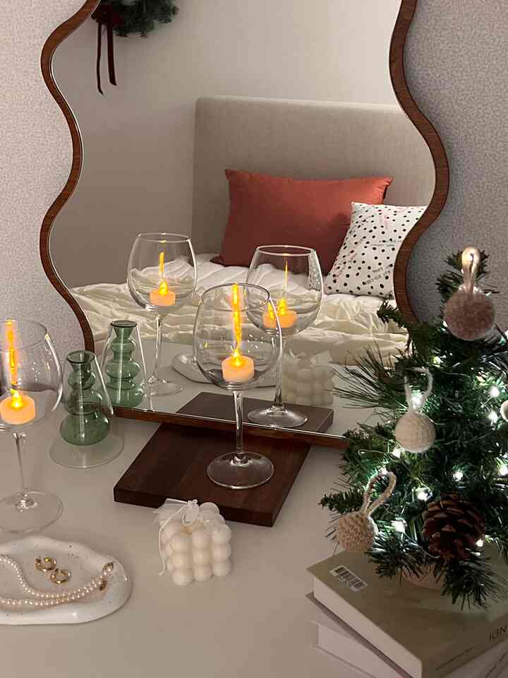 ホワイトとグリーンの色調の寝室の化粧台スペース、ミニツリーとワイングラスにLEDキャンドルが配置された雰囲気のあるインテリア
