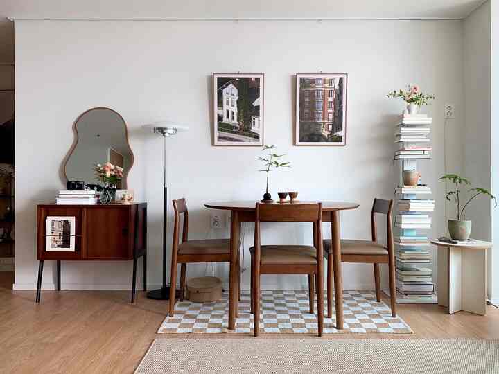 Natural dining room with white walls and wood tone furniture, featuring a dining table with four chairs centrally placed in a cozy setting