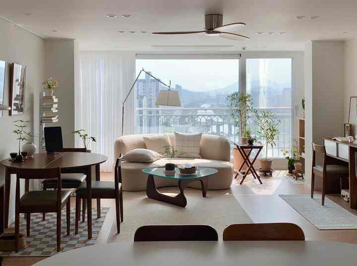 Bright and cozy living and dining room in white and wood tones featuring natural modern style sofa and dining table