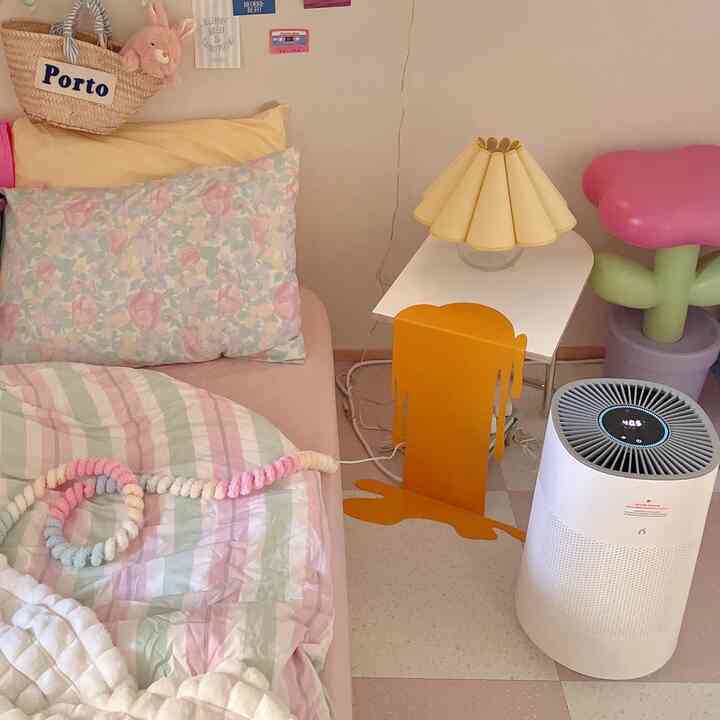 パステル調でナチュラルな寝室、赤ちゃんと暮らす空間で、ベッドとテーブルランプ、空気清浄機が配置された雰囲気のあるインテリア