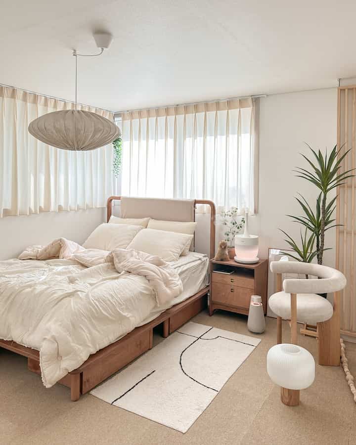 Natural modern bedroom with wooden bed and nightstand, cream curtains, artificial tree, creating a cozy atmosphere