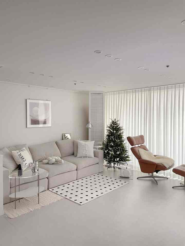 White-toned living room featuring beige sofa and brown recliner chair creating a clean, modern space