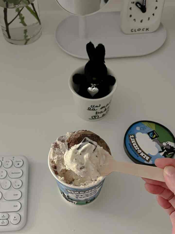 白を基調とした机の上にベン＆ジェリーズのアイスクリームと黒いうさぎのキーホルダーが置かれた、落ち着いたミニマルな空間