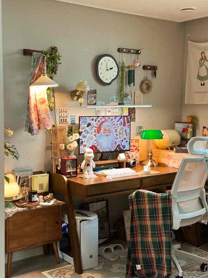 ブラウンとベージュの色調の小さな部屋、デスクと壁時計、ヴィンテージ調のインテリアが配置された雰囲気のあるホームオフィス