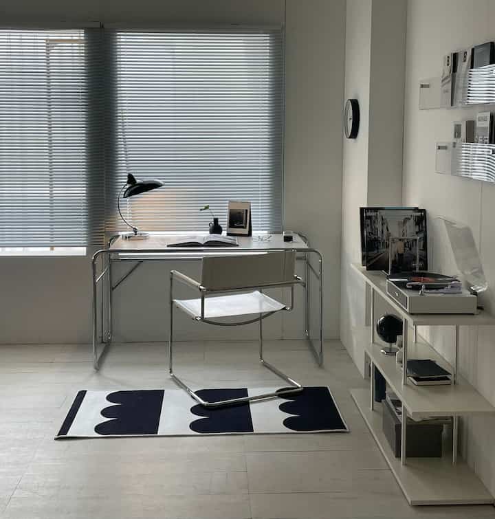 A white and chrome mid-century modern study featuring a chrome table and chair with a clean, simple atmosphere