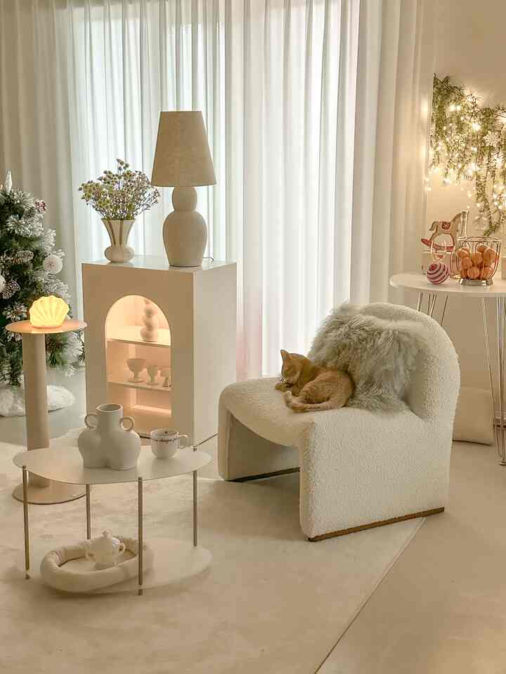 白とベージュの色調のリビング、柔らかいソファと猫が配置された雰囲気のあるインテリア