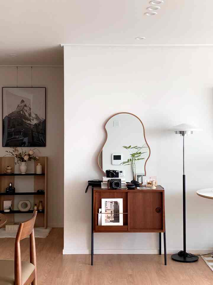 Natural tone walls and wood-toned furniture with a floor lamp in a modern living room