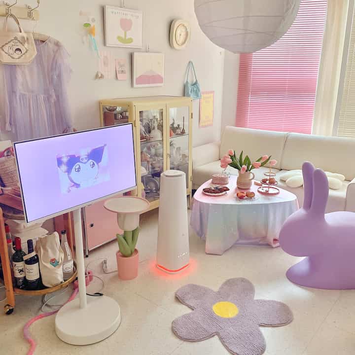 White and pink-toned living room with a modern kids' room vibe featuring a humidifier, TV stand, and cozy interior