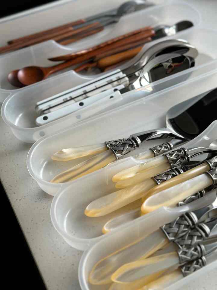 白と透明の収納ケースに様々なカトラリーが整理されたキッチンの雰囲気あるインテリア