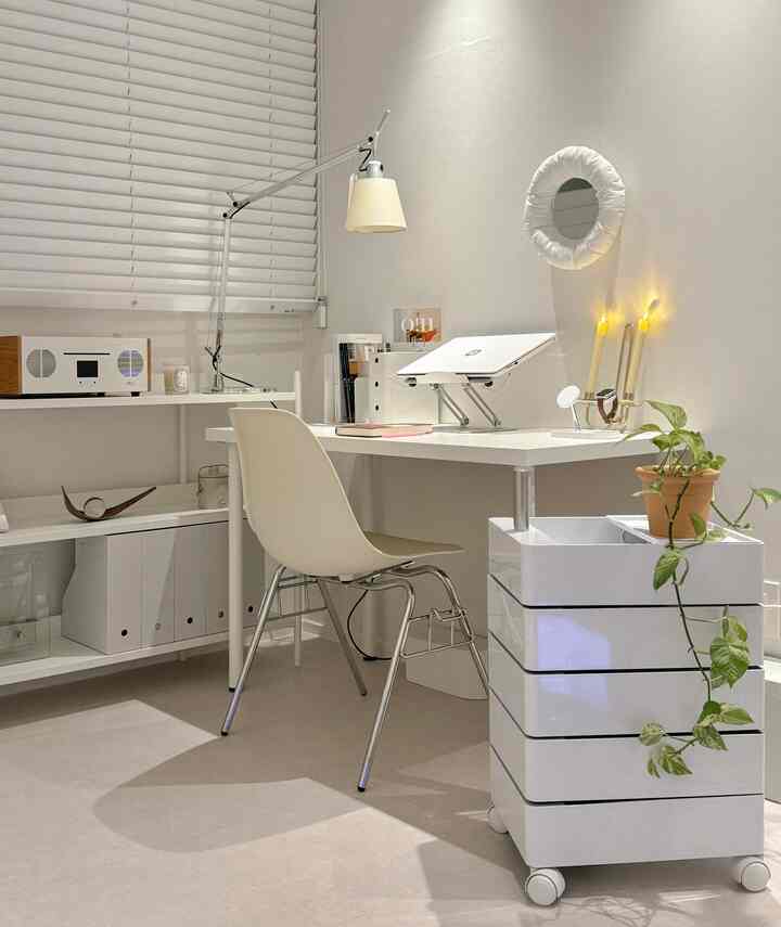 白色のトーンの書斎、白いデスクと椅子、整理された収納と観葉植物が配置されたモダンでシンプルなインテリア