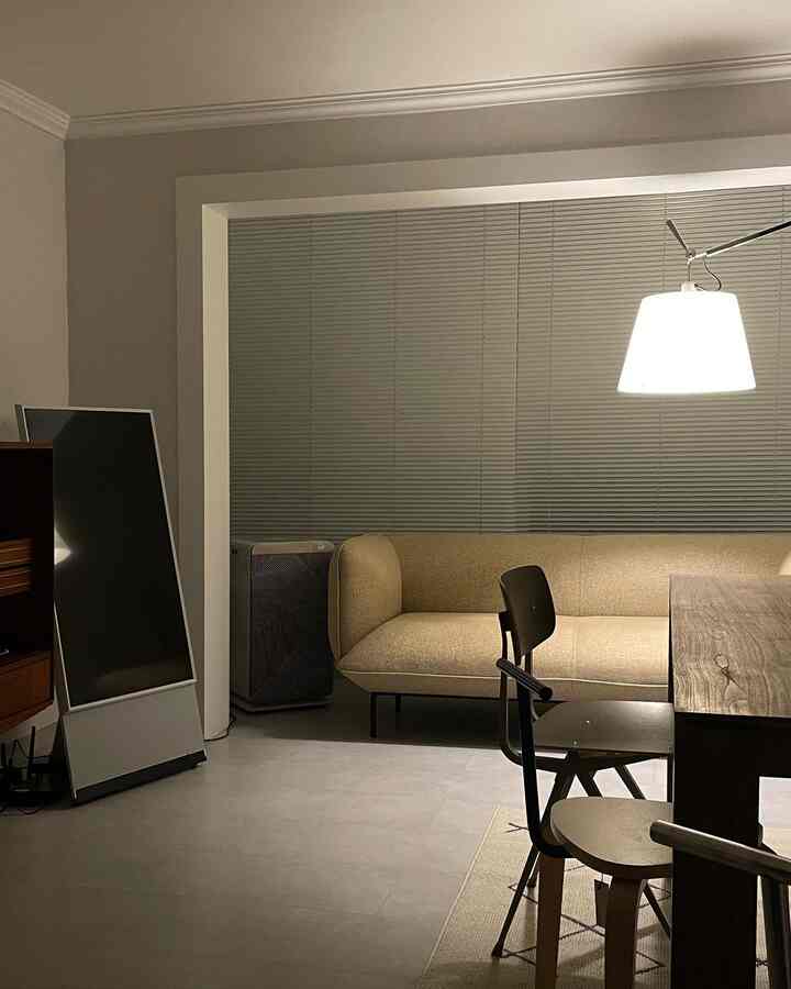 ベージュのソファと木目調のダイニングテーブルが配置された、ブラインドの窓が特徴的なナチュラルモダンなリビングダイニング