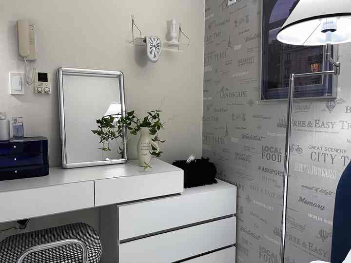 White and blue toned vanity space featuring a melting clock and green plant accents within a modern, compact room