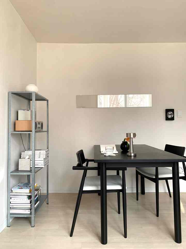 Ivory-toned dining room for two featuring a black dining table and chairs in a clean, modern space