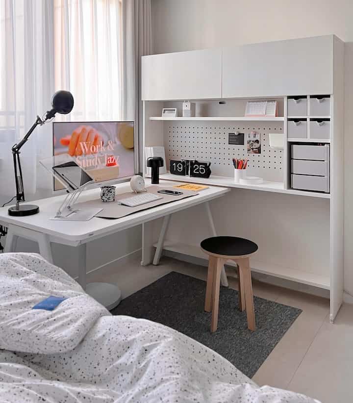 White-toned kids' room home office featuring a simple white desk with storage, creating a modern and clean atmosphere