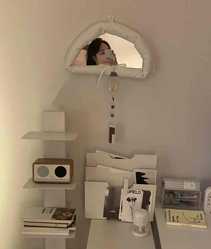 ホワイトトーンの在宅勤務用ホームオフィス、机と照明、ブルートゥーススピーカーが配置されたミニマルなインテリア