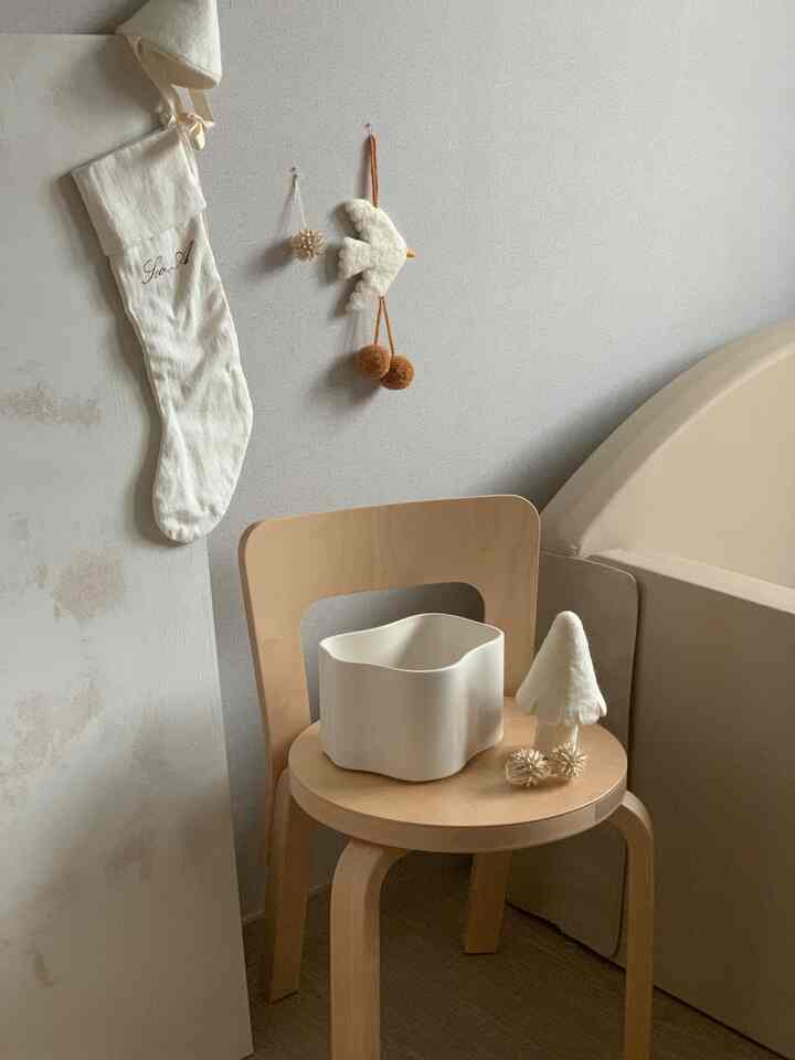 Natural color kids' room featuring wooden chair and bed frame with cozy Christmas decorations