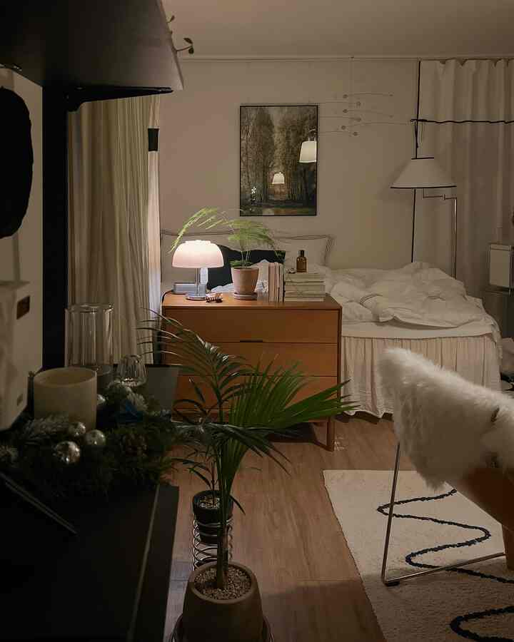 Natural modern bedroom featuring wood-toned furniture, potted plants, and soft lighting creating a cozy atmosphere