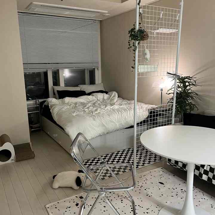 モノトーンの白黒ベッドルーム、シンプルでモダンなソファと多機能パーティションが配置された落ち着いた空間