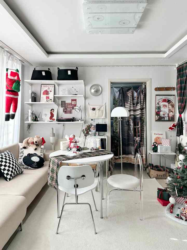 White and beige toned living room featuring Christmas decorations, sofa, table, and tree in a cozy modern setting