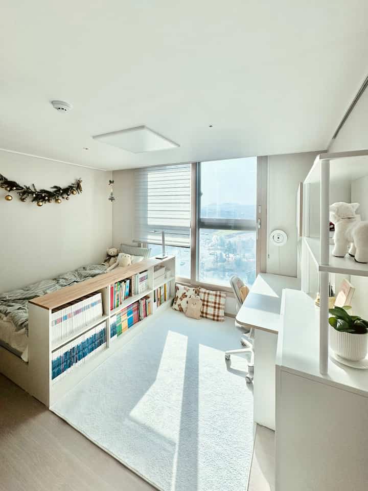 白とナチュラルトーンの小学生の部屋、本棚付きベッドとデスクで空間を仕切った明るくすっきりとした雰囲気の勉強部屋インテリア